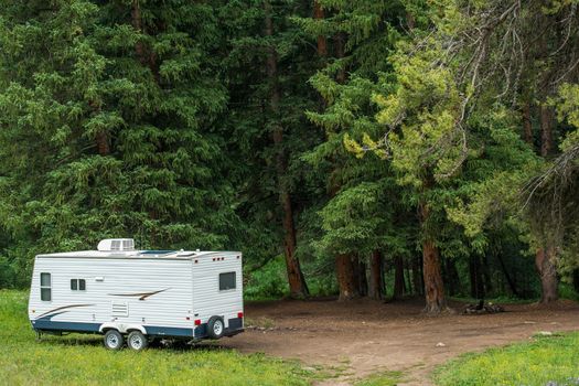 Boondocking Dry Camping in the Forest. Small Travel Trailer with Solar Panels on Roof.