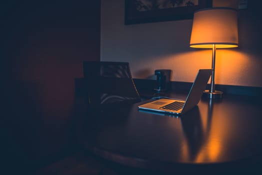 Night Work Desk. Dark Serene Theme with Laptop and Night Lighting.
Wooden Desktop.