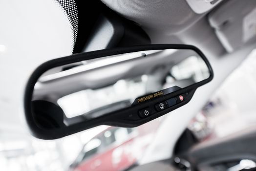 Rear View Interior Car Mirror with Safety Buttons and Passenger Airbag Indicator Closeup.