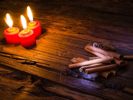 cinnamon sticks on brown wooden tables and red candles