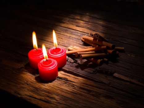 cinnamon sticks on brown wooden tables and red candles