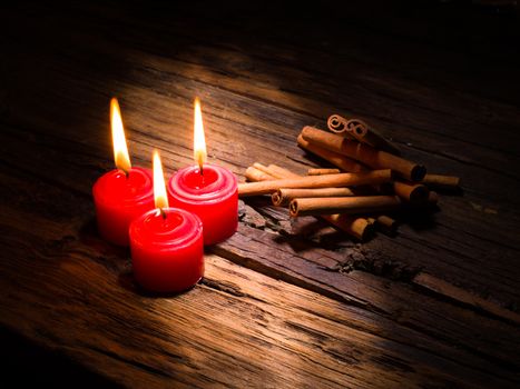 cinnamon sticks on brown wooden tables and red candles