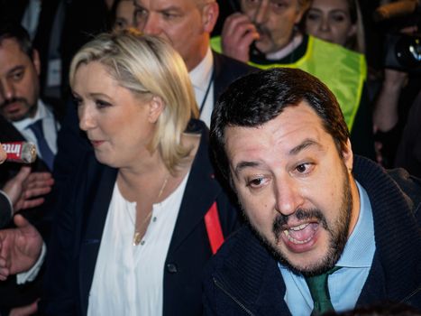 ITALY, Milan: Italian Secretary of the Northern League Matteo Salvini (right) addresses the crowd outside before a political rally also attended by French President of the National Front Marine Le Pen (left) and other officials at MiCo in Milan, Italy on January 28, 2016. At the same time, demonstrators from the Anti-Fascist Network of Milan march through the city and launch fireworks to protest their meeting.