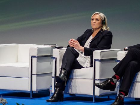 ITALY, Milan: French President of the National Front Marine Le Pen listens during a political rally also attended by Italian Secretary of the Northern League Matteo Salvini and other officials at MiCo in Milan, Italy on January 28, 2016. At the same time, demonstrators from the Anti-Fascist Network of Milan march through the city and launch fireworks to protest their meeting.