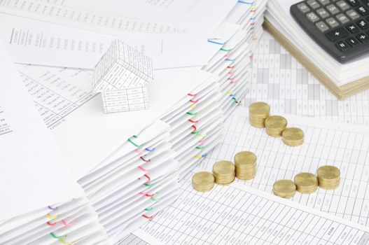 House on pile of document with colorful paperclip have step pile of gold coins and calculator on paperwork and brown envelope as background.