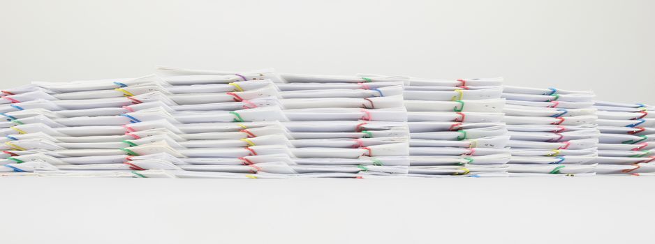 Pile document of receipt and report with colorful paperclip on white background.