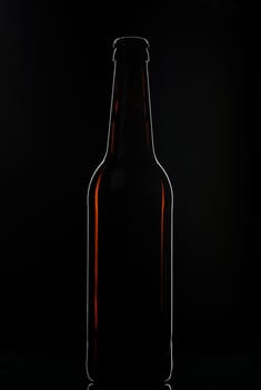 silhouette of brown beer bottle on black backdrop