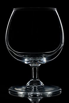 silhouette of Empty cognac glass on black backdrop