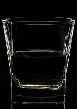 Glass with whisky on black background