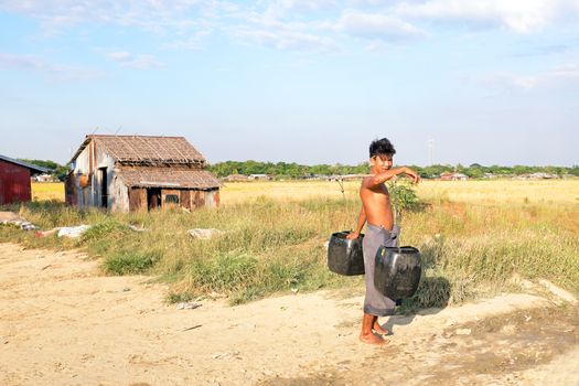 YANGON, MYANMAR - November 25, 2015: Water carrier with two buckets getting water in the countryside from Myanmar