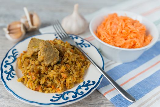 Plate of rice and meat national dish pilau with carrot salad