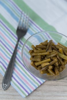 Plate of the prepared green beans and fork on the napkin