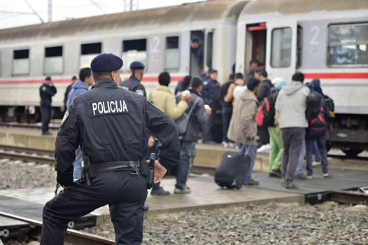 October 5, 2015; Tovarnik in Croatia. Croatian police assist refugees get into train which will go to Hungary.