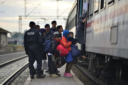 October 5, 2015; Tovarnik in Croatia. Croatian police assist refugees get into train which will go to Hungary.