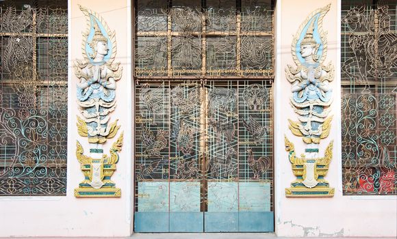 Forged iron door at a temple building at a monastery in Myeik, Tanintharyi Region, South Myanmar, with illustrations from Buddhist history and Asian mythology.
