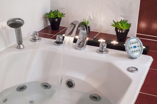 Jacuzzi bath with water, candles and plants
