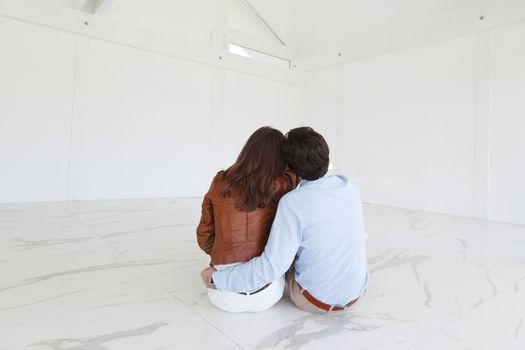 Couple sitting at their new empty apartment