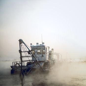  dredge boat in the fog in winter