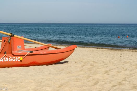 Red lifeboat on the beautiful sicilian beach