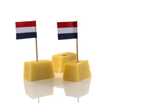 blocks of yellow Dutch cheese with Dutch flag in red white blue toothpicks on a white background