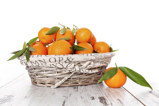 Mandarine fruit in white wooden basket on white wooden table. Provence style.