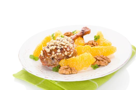 Culinary roast duck with oranges and nuts on plate isolated on white background. Delicious festive eating. 