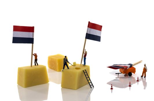 little people putting the dutch red white and blue flags on dutch cheese