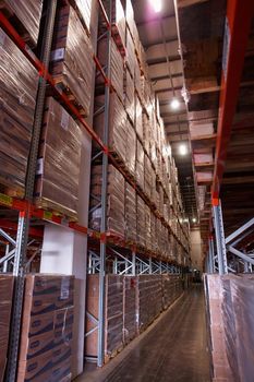 Large modern warehouse logistics center with rows of shelves with boxes