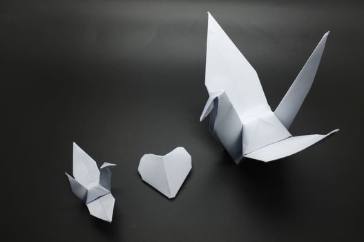 White origami crane and heart between, bird paper