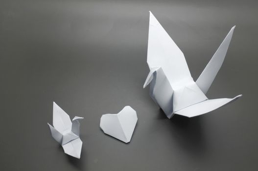 White origami crane and heart between, bird paper