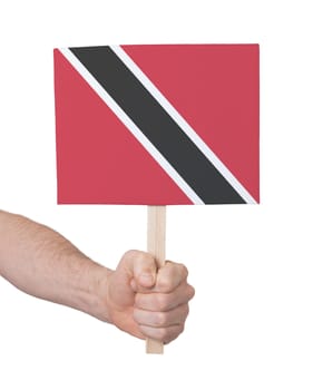 Hand holding small card, isolated on white - Flag of Trinidad and Tobago