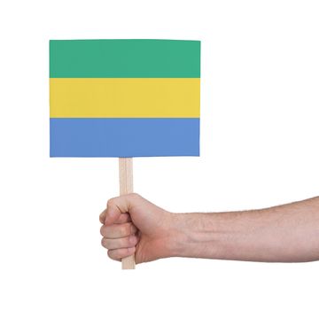 Hand holding small card, isolated on white - Flag of Gabon