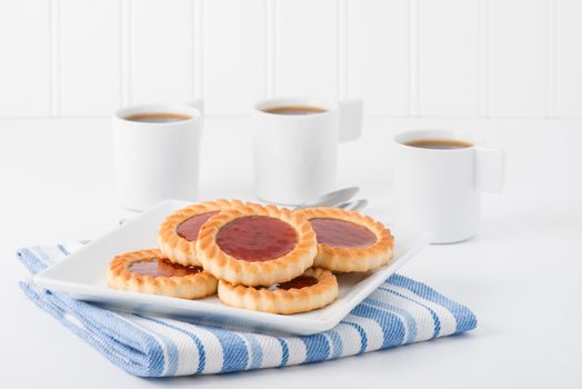 Plate of jelly filled biscuits served with coffee.
