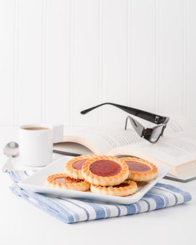 Plate of jam filled cookies and coffee to portray the concept of taking a break.