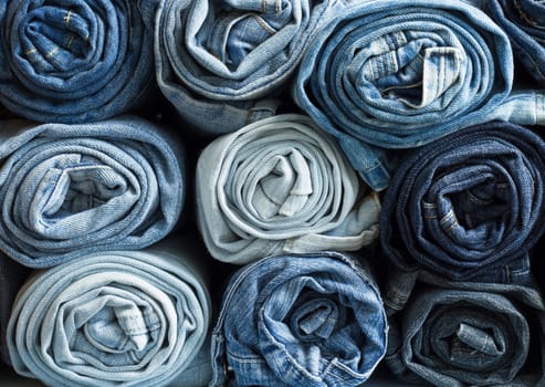 Roll blue denim jeans arranged in stack 