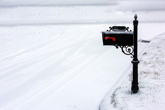 A black mailbox covered with fresh white snow