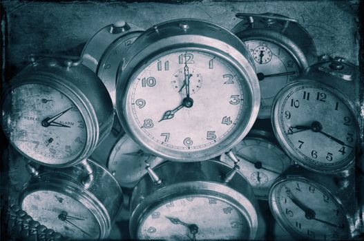 Closeup of textured image of vintage alarm clocks in blue.