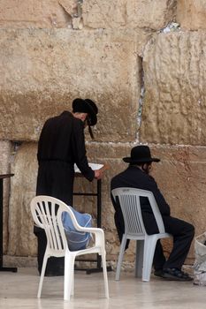 Jewish men pray at the western wall October 03, 2006 in Jerusalem, IL. The wall is one of the holiest sites in Judaism attracting thousands of worshipers daily.