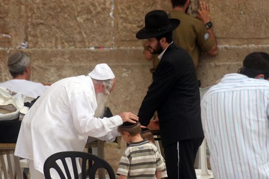 Jewish men pray at the western wall October 03, 2006 in Jerusalem, IL. The wall is one of the holiest sites in Judaism attracting thousands of worshipers daily.