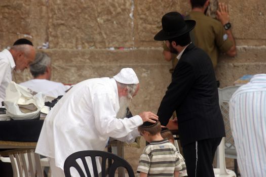 Jewish men pray at the western wall October 03, 2006 in Jerusalem, IL. The wall is one of the holiest sites in Judaism attracting thousands of worshipers daily.