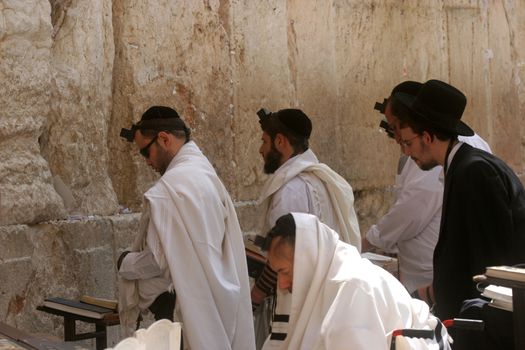 Jewish men pray at the western wall October 03, 2006 in Jerusalem, IL. The wall is one of the holiest sites in Judaism attracting thousands of worshipers daily.