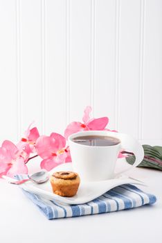 Mini cinnamon roll served with a cup of hot tea.