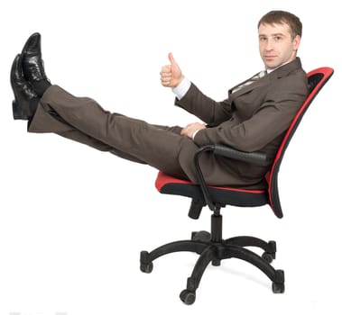 Businessman sitting on chair with legs up and showing ok isolated on white background, side view