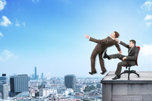 Businessman sitting on chair and kicking man from building roof