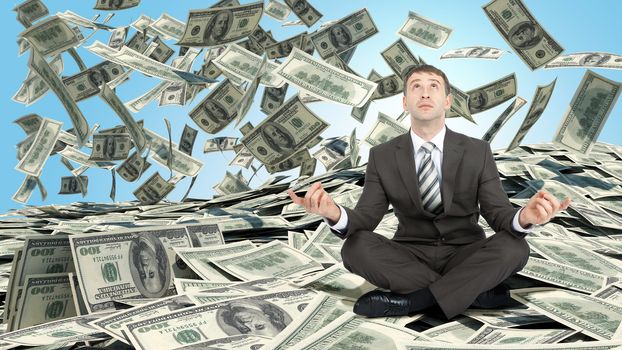 Businessman sitting in lotus posture on pile of cash