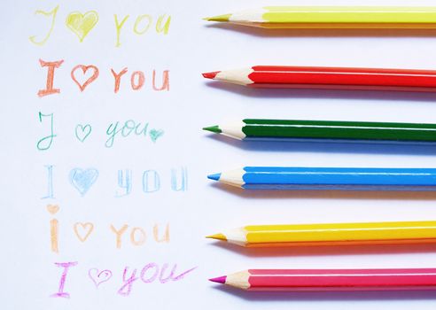 Paper with love you message and colored pencils