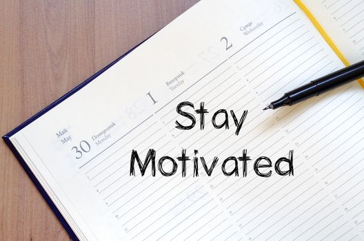Stay motivated text concept write on notebook with pen