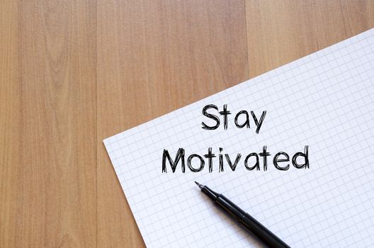 Stay motivated text concept write on notebook with pen