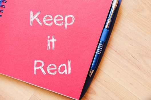 Keep it real text concept write on notebook with pen