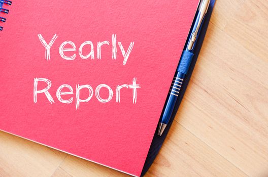 Yearly report text concept write on notebook with pen